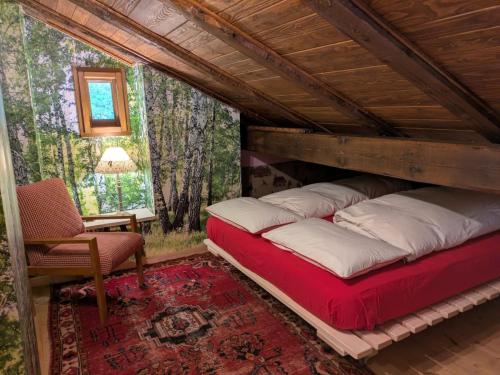 a bedroom with a bed and a chair in a room at Baita Nido tra i Monti in Daone
