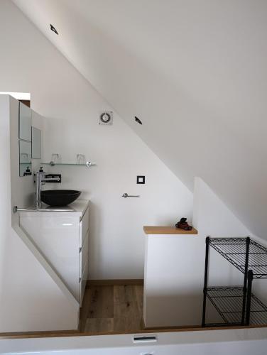 a white bathroom with a sink and a mirror at " Al'Coppette " Gîte open-space in Comblain-au-Pont