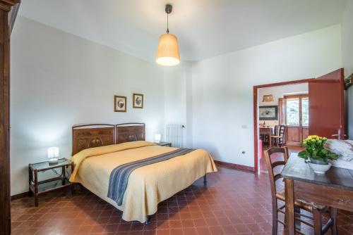 a bedroom with a bed and a table and chairs at Podere del Pereto Bio- 201 in Rapolano Terme
