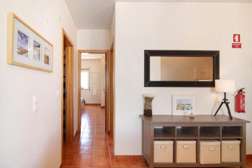 a hallway with a table and a mirror on a wall at Quinta Gomeira 146 in Cabanas de Tavira
