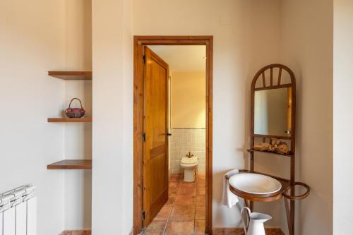 a bathroom with a toilet and a mirror at Cal Cirera in Sagás