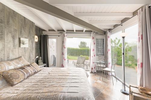 a bedroom with a large bed and a balcony at Sítio das Rolas - Selão da Eira in São Teotónio