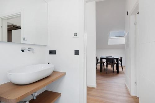 ein weißes Badezimmer mit Waschbecken und ein Esszimmer in der Unterkunft Maso Renner in Leifers