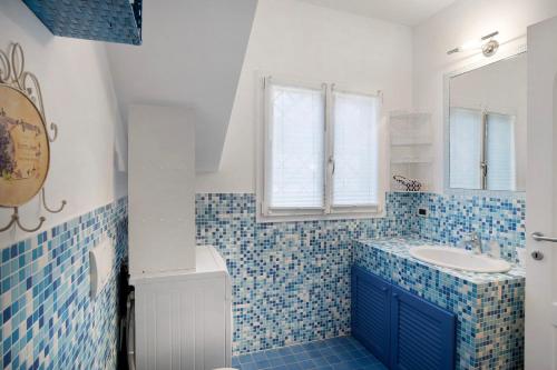 a blue and white bathroom with a sink and a mirror at Villa di Diana in Diano Castello