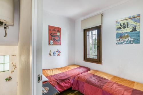 two beds in a room with a window at Set Cases in L'Escala