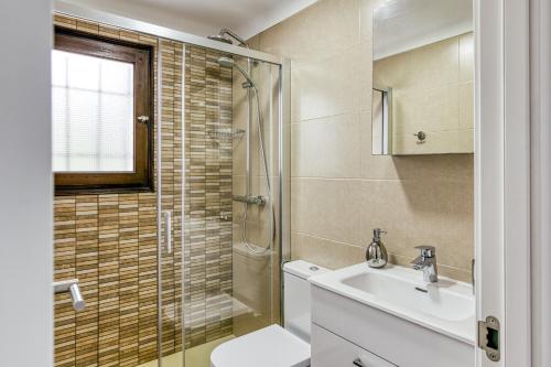 a bathroom with a toilet and a sink and a shower at Set Cases in L'Escala