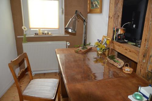 a kitchen with a wooden table and a window at Ferienwohnung Harz Idylle in Güntersberge