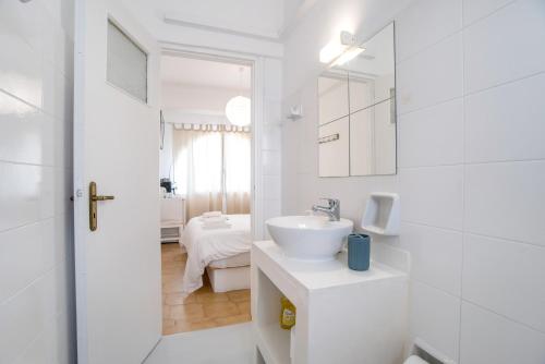 a white bathroom with a sink and a mirror at Livadia Seaside Studios 8 in Parikia