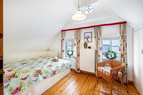 a bedroom with a bed and a chair at Weitblick in Wesselburen