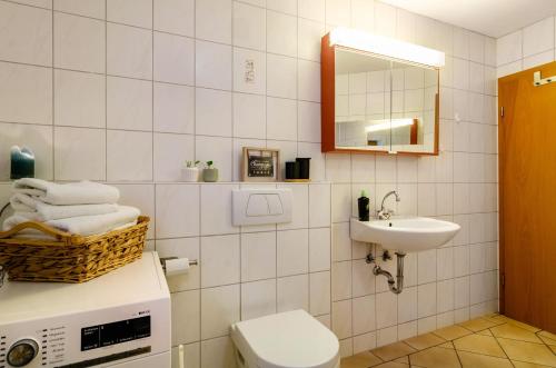 ein Badezimmer mit Waschbecken, Toilette und Spiegel in der Unterkunft Donauliebe in Sigmaringen