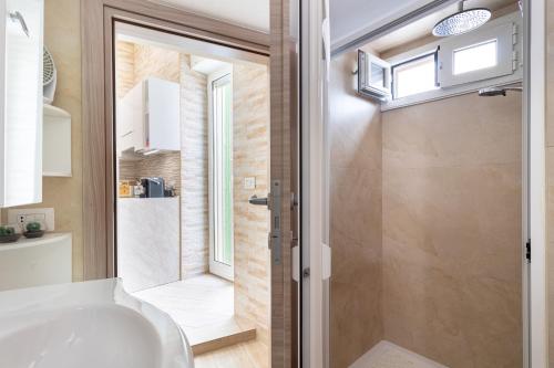 a bathroom with a tub and a shower with a window at Zelda Casa Vacanza in Giovinazzo