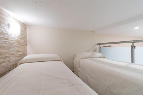 two beds in a room with a brick wall at Zelda Casa Vacanza in Giovinazzo