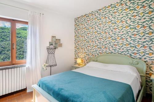 a bedroom with a bed and a wall with a patterned wall at La casa di Bosco in Casanova Lerrore
