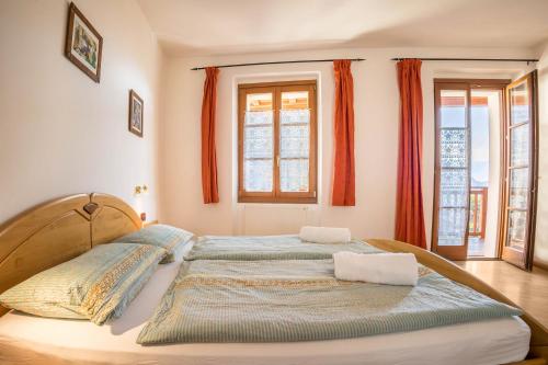 a large bed in a bedroom with orange curtains at Residence Lena App 3 with Balcony in Tenno