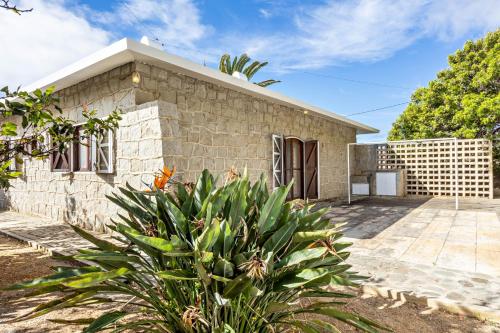 a stone house with a plant in front of it at Casa da Praia in Vila Baleira