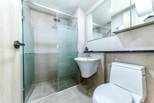 a bathroom with a toilet and a glass shower at Hu An Stay Hotel in Seogwipo