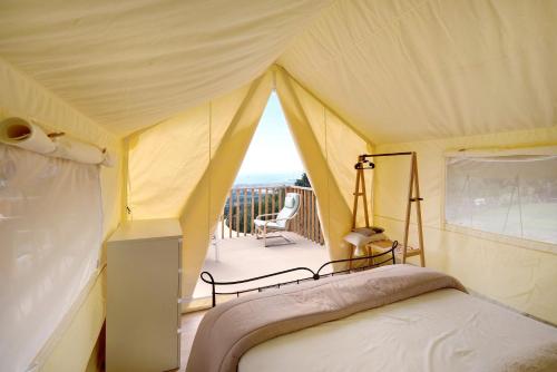 a bedroom with a bed in a tent with a balcony at Glamping Ripa Garden Montestella in Salerno