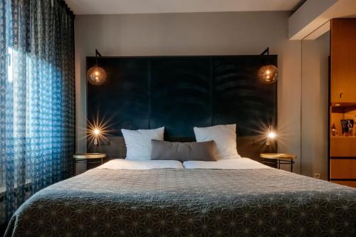 a bedroom with a large bed with a large headboard at Hotel Derlon in Maastricht