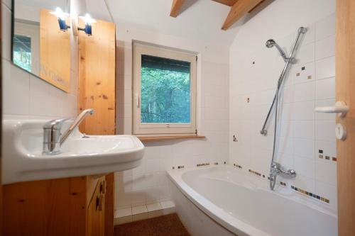 a bathroom with a sink and a bath tub at Ferienhaus am Brandorffsee in Wiefelstede