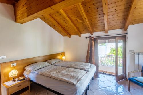 a bedroom with a bed with a wooden ceiling at Casa Rita app 1 in Tremosine Sul Garda
