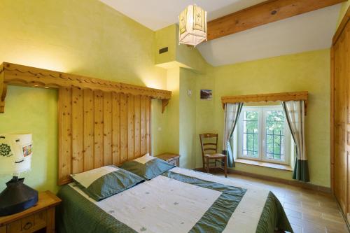 a bedroom with a large bed with a wooden headboard at Le Calmadou in Formiguères
