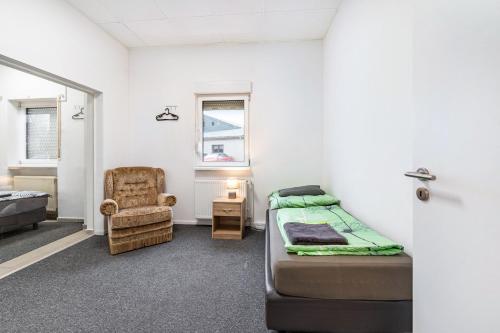 a room with a bed and a chair in it at Saarglück - W4 in Beckingen