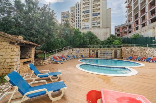 a swimming pool with lounge chairs and a table at Squash Club Portimão in Portimão