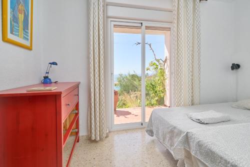 a bedroom with a bed and a sliding glass door at Casa Beto in Almuñécar