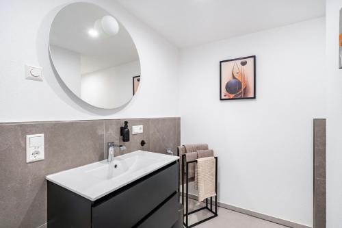 a bathroom with a sink and a mirror at Fewo Blumenweg in Elzach
