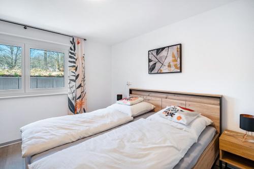 two beds in a room with a window at Fewo Blumenweg in Elzach