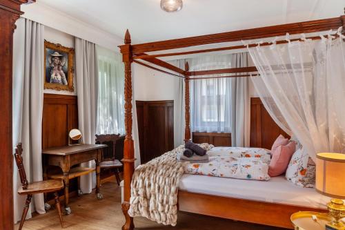 a bedroom with a canopy bed and a desk at Apartment Villa Stumm in Stumm