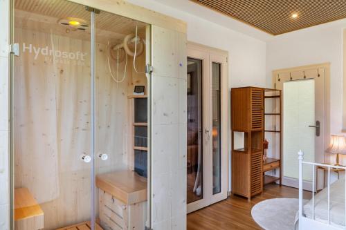 a glass shower in a room with wooden walls at Apartment Villa Stumm in Stumm