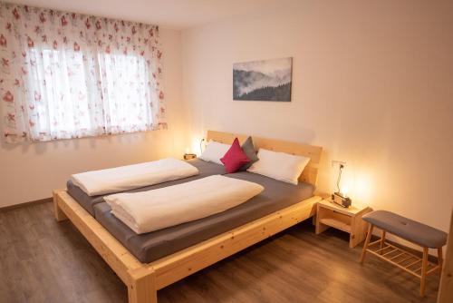 a bedroom with a wooden bed with two pillows at Bergstern in Freudenstadt