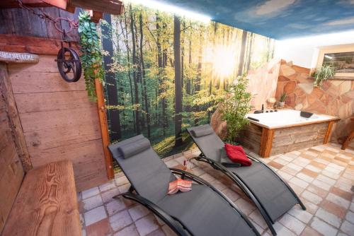 a bathroom with two chairs in front of a mural at Bergstern in Freudenstadt