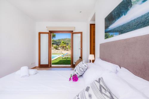 a bedroom with a large white bed with flowers on it at Can Bosco in Son Servera