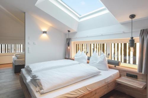 a bedroom with a bed with white sheets and a window at Innerbachlerhof - Mut in Postal