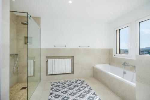 a bathroom with a tub and a glass shower at Can Eolo in Capdepera