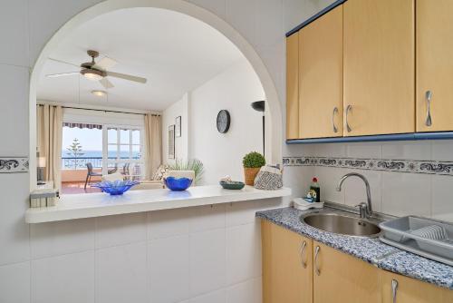 a kitchen with a sink and a window with a view at Jardines del Mar in Torrox