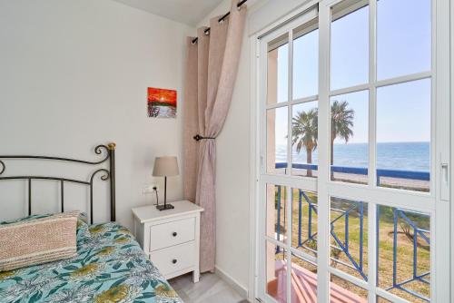 a bedroom with a bed and a view of the ocean at Jardines del Mar in Torrox