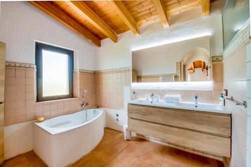 a bathroom with a large tub and a large mirror at Finca Kiana in Sencelles