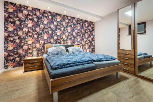 a bedroom with a bed with a floral wallpaper at Ferienwohnung Silberborth mit Sauna in Seesen
