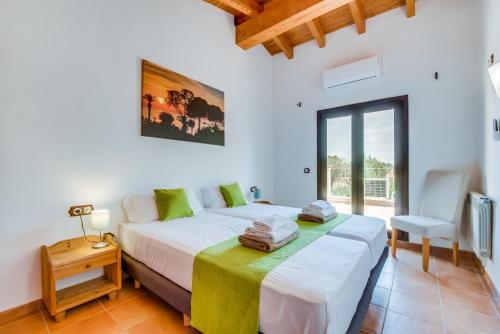 a bedroom with a bed and a table and a chair at Finca Kiana in Sencelles