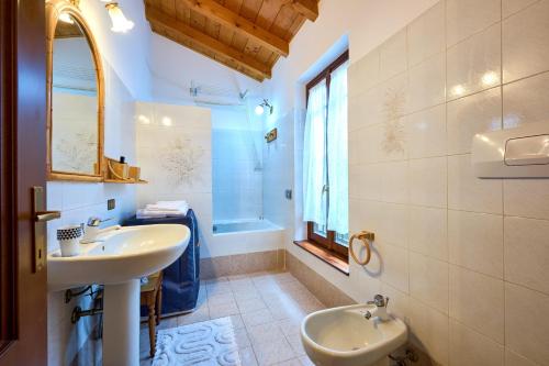 a bathroom with a sink and a toilet and a window at Casa Bruna - 100m dal Lago Maggiore in  Monvalle 