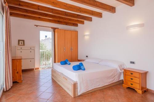 a bedroom with a bed with blue pillows on it at Villa Payu in Ciutadella
