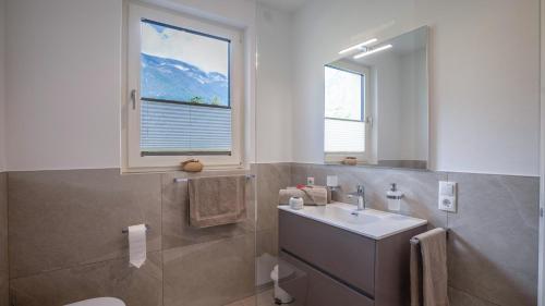 a bathroom with a sink and a toilet and a window at Meine Bleibe Apartment Terra in Appiano sulla Strada del Vino