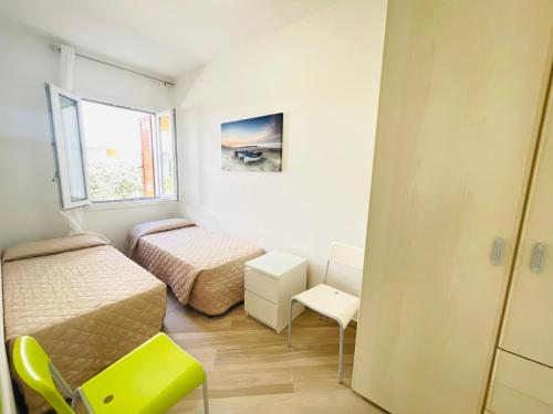 a small bedroom with two beds and a window at Villa Raffaella - Privat Garden in Bibione