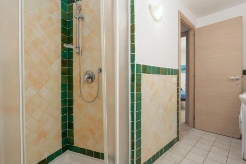 a bathroom with a shower with green tiles at Residence Orizzonti app n 21 in Golfo Aranci