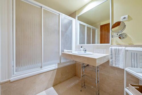 a bathroom with a sink and a mirror at Ática Blue Sea in Cubelles
