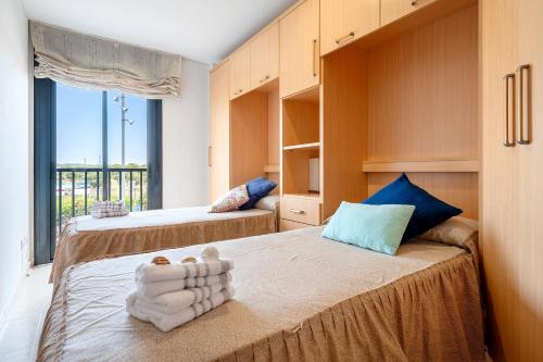 a bedroom with two beds and a large window at Ática Blue Sea in Cubelles