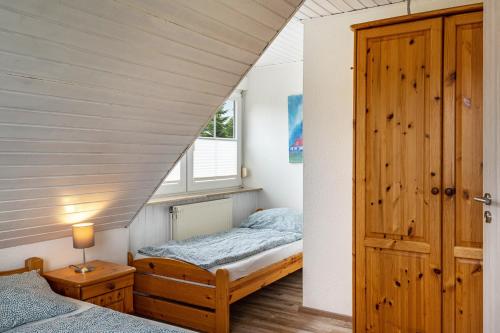 a bedroom with two beds and a window at Kleiner Leuchtturm - Steuerbord in Fehmarn
